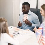 Teacher guiding diverse students in an English language lesson with a British flag card. - Photo by Gustavo Fring on Pexels