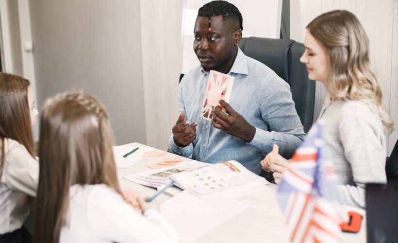 Teacher guiding diverse students in an English language lesson with a British flag card. - Photo by Gustavo Fring on Pexels