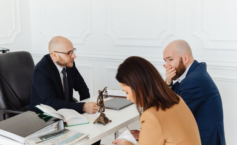 A serious legal consultation in a professional office environment involving three adults. - Photo by www.kaboompics.com on Pexels