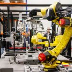 Close-up of a yellow industrial robotic arm in action at a modern manufacturing facility. - Photo by Freek Wolsink on Pexels