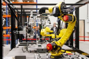 Close-up of a yellow industrial robotic arm in action at a modern manufacturing facility. - Photo by Freek Wolsink on Pexels
