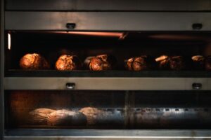 Warm artisan bread being baked to perfection in a professional industrial oven. - Photo by Chris F on Pexels