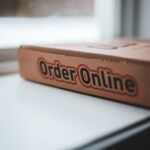 Soft focus of cardboard box of delivery pizza online service placed on white windowsill in daylight - Photo by Erik Mclean on Pexels