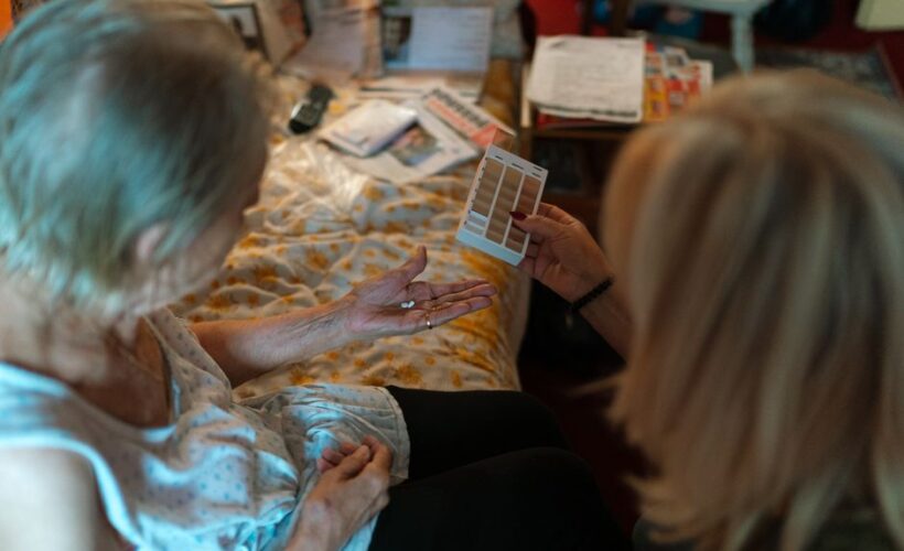 An elderly woman receives medication assistance at home, emphasizing home healthcare and caregiver support. - Photo by Jsme MILA on Pexels